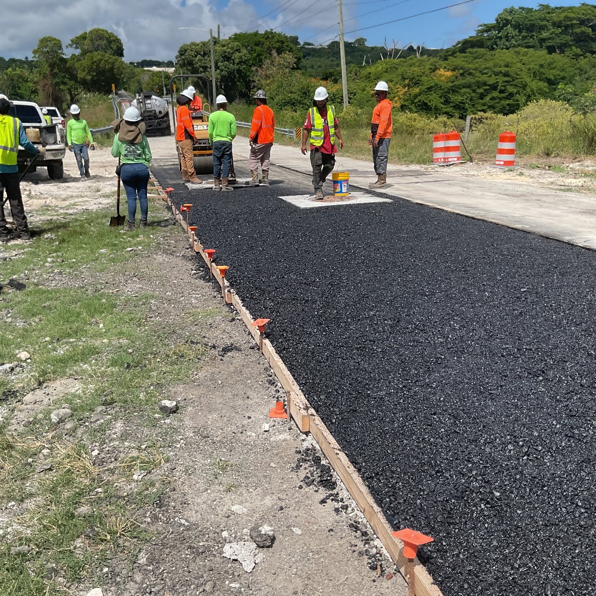 A paving crew laying fresh asphalt to restore the road over the duct bank.