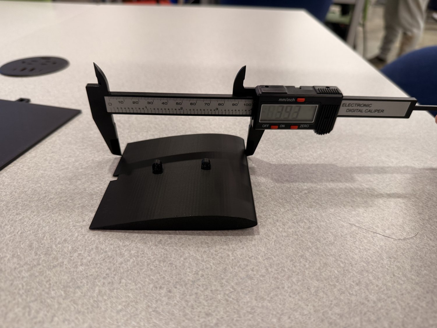 Measuring a printed model with digital calipers.
